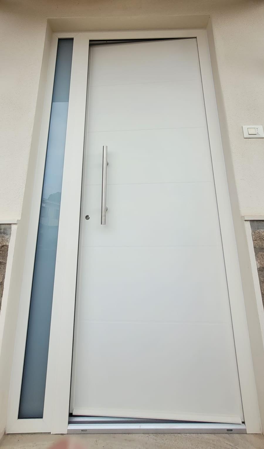 Porta di ingresso bianca con maniglione e vetro laterale